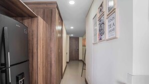 Un pasillo con refrigerador, gabinetes de madera y dispensador de agua.