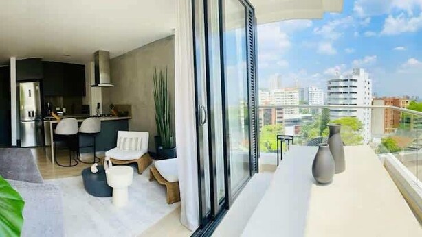 Un appartement moderne doté d’un balcon, d’une cuisine et offrant une vue sur la ville.