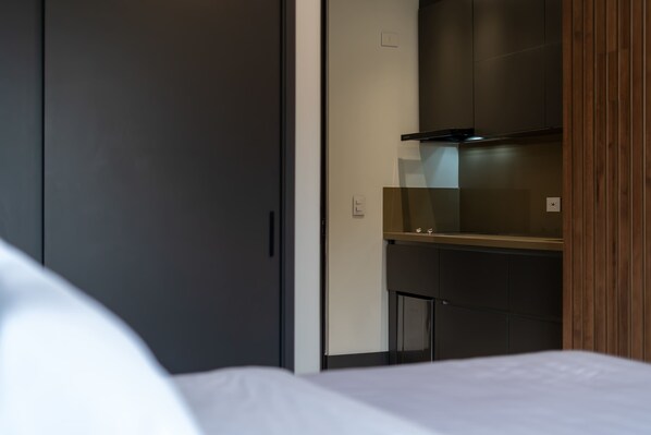 A hotel room with a bed, a wardrobe, and a built-in microwave.