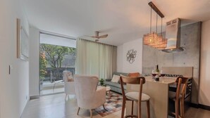 Una cocina moderna con comedor, un ventanal grande y un ventilador de techo.