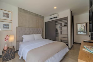 A bedroom with a bed, bedside table, lamp, and a wardrobe. - RM 308 | Luxury | Pool & Parking | Santa Teresita (Cali)