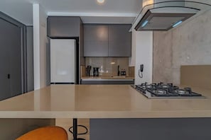 A modern kitchen with a central island, a built-in oven, and a gas stove. - RM 308 | Luxury | Pool & Parking | Santa Teresita (Cali)