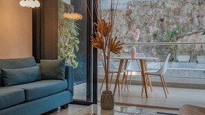 A modern living room with a sofa, a glass coffee table, a vase with dried plants, and a dining area with a table and chairs. - RM 308 | Luxury | Pool & Parking | Santa Teresita (Cali)