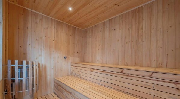 A sauna room with wooden walls and benches. - RM 311 |  Luxurious 1-Bed | Gym | Pool | Security (Cali)