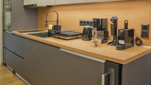A modern kitchen with a wooden countertop, built-in appliances, and a sleek design. - Stylish Ilisia Stay Luxury Fully Reno 2BR, 2BA Apt (Athens)