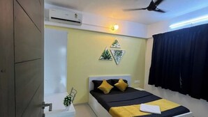 Une chambre à coucher comprenant un lit, une table de chevet et un appareil de climatisation.