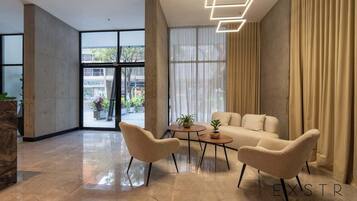 Un interior moderno con zona de estar, un ventanal con cortinas y vistas al exterior.