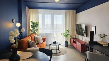 Apartamento superior, balcón, vistas a la ciudad | Sala de estar | Smart TV de 50 pulgadas con canales por cable, Netflix