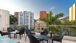 Une terrasse sur le toit, avec des sièges en plein air et une vue sur la ville.