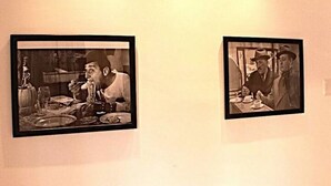 Deux photographies en noir et blanc encadrées représentant des personnes à table.