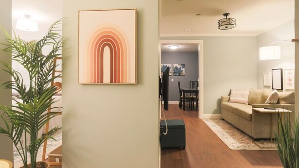 Een woonkamer met een bank, een salontafel en een eethoek met stoelen en een tafel.