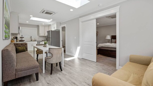Un appartamento moderno con zona pranzo, cucina e camera da letto.