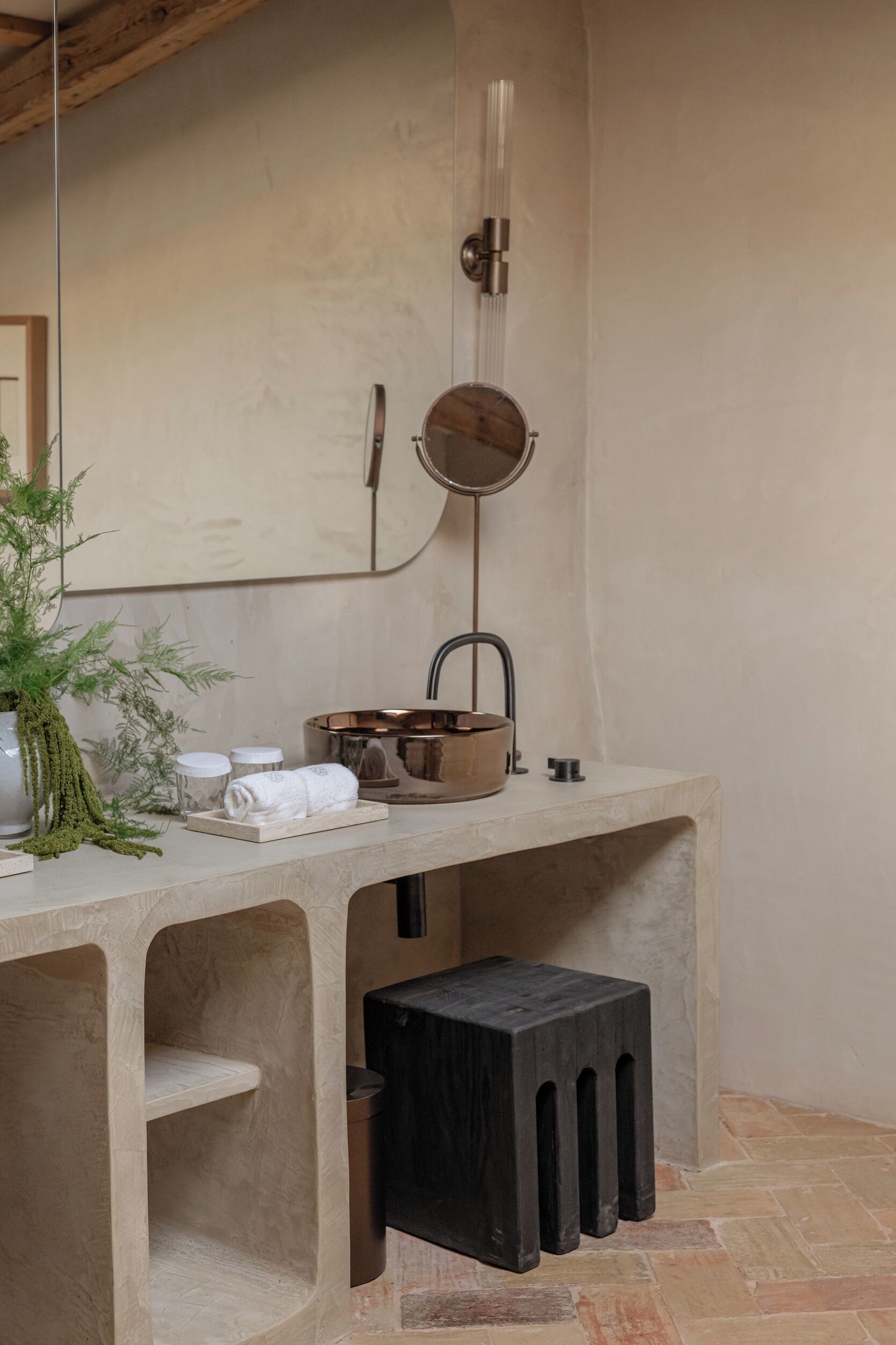 Une salle de bain avec un lavabo en pierre, un miroir et un porte-serviettes.