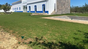 A modern building with a white exterior and blue accents, featuring a large lawn and a swimming pool. - Quinta da Pisilveira (Loulé)