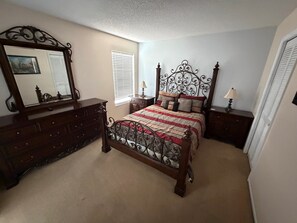 A bedroom with a bed, dresser, mirror, bedside tables, and a window with blinds. - Executive Vacation Home Near Disney Perfect for Large Families! (Davenport)