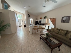 A spacious living area with a kitchen, a dining area with chairs, a sofa, and a coffee table.