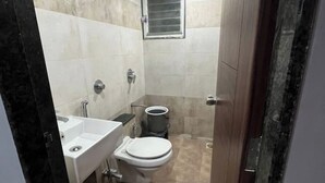 Ein kleines Badezimmer mit Toilette, Waschbecken und Dusche.