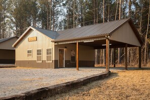 A single-story building with a covered porch and a small entrance. - Cabins of Lay Lake at Beeswax Cabin #2 (Wilsonville)