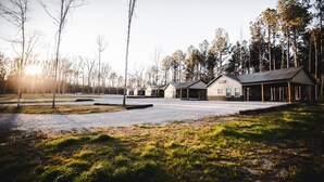 A row of modern buildings with large windows and a gravel driveway.