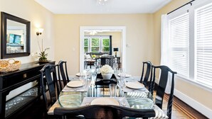 A dining area with a glass table set for six, black chairs, a ceiling fan, and a view of a living room through an open doorway. - Daily Double-Expo, UofL, Downtown, Highlands, close to track, NEW LISTING! (Louisville)
