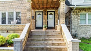 A two-story house with a brick exterior, numbered 552, featuring a front porch with steps, a small garden, and a mailbox. - Daily Double-Expo, UofL, Downtown, Highlands, close to track, NEW LISTING! (Louisville)