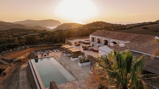 A resort with a swimming pool, outdoor seating, and a view of the surrounding landscape. - Hotel Vestige Son Ermità (Ferreries)