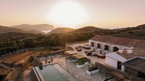 A villa with a swimming pool, outdoor seating, and a view of the surrounding landscape. - Hotel Vestige Son Ermità (Ferreries)