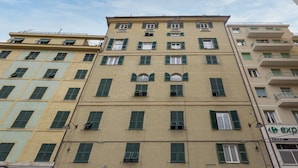 A multi-story building with a beige facade and green shutters. - Les Suites del Carmine 3 by Wonderful Italy (Genoa)