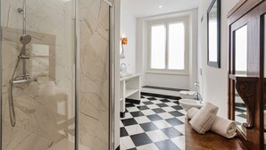 A bathroom with a glass-enclosed shower, a sink, a toilet, and a checkered floor. - Les Suites del Carmine 3 by Wonderful Italy (Genoa)