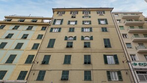 A multi-story building with a beige facade and green shutters. - Le Suite del Carmine 1 by Wonderful Italy (Genoa)