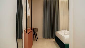 Una habitación de hotel con una cama, un escritorio y una silla.