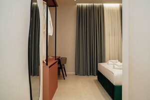 Una habitación de hotel con una cama, un escritorio y una silla.