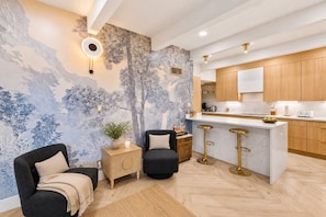 Una cocina moderna con una isla central, armarios de madera y un mural decorativo.