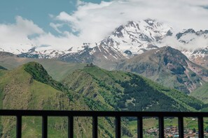 A mountainous landscape with a small building on a hill. - Residence Kazbegi (Stepantsminda)