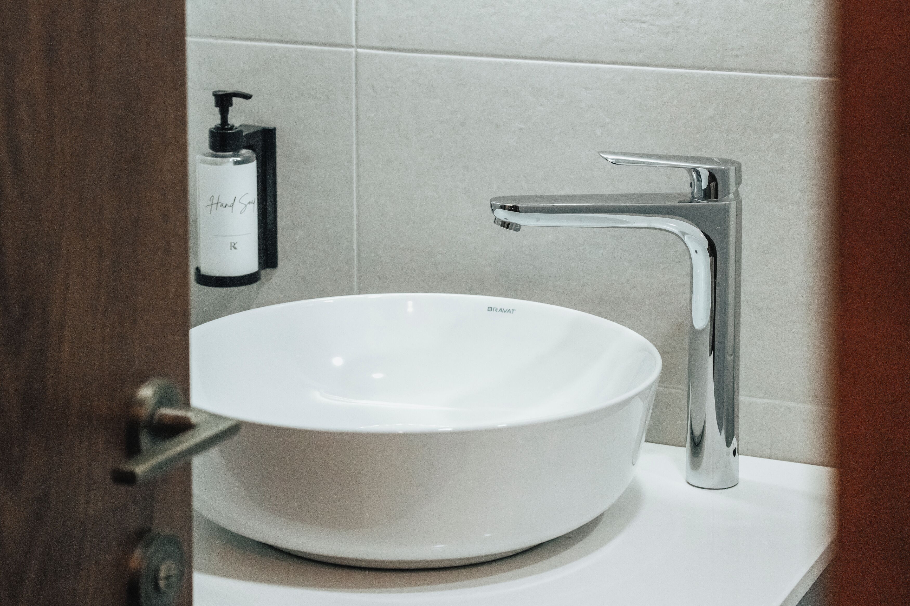 A white ceramic sink with a chrome faucet on a white countertop.