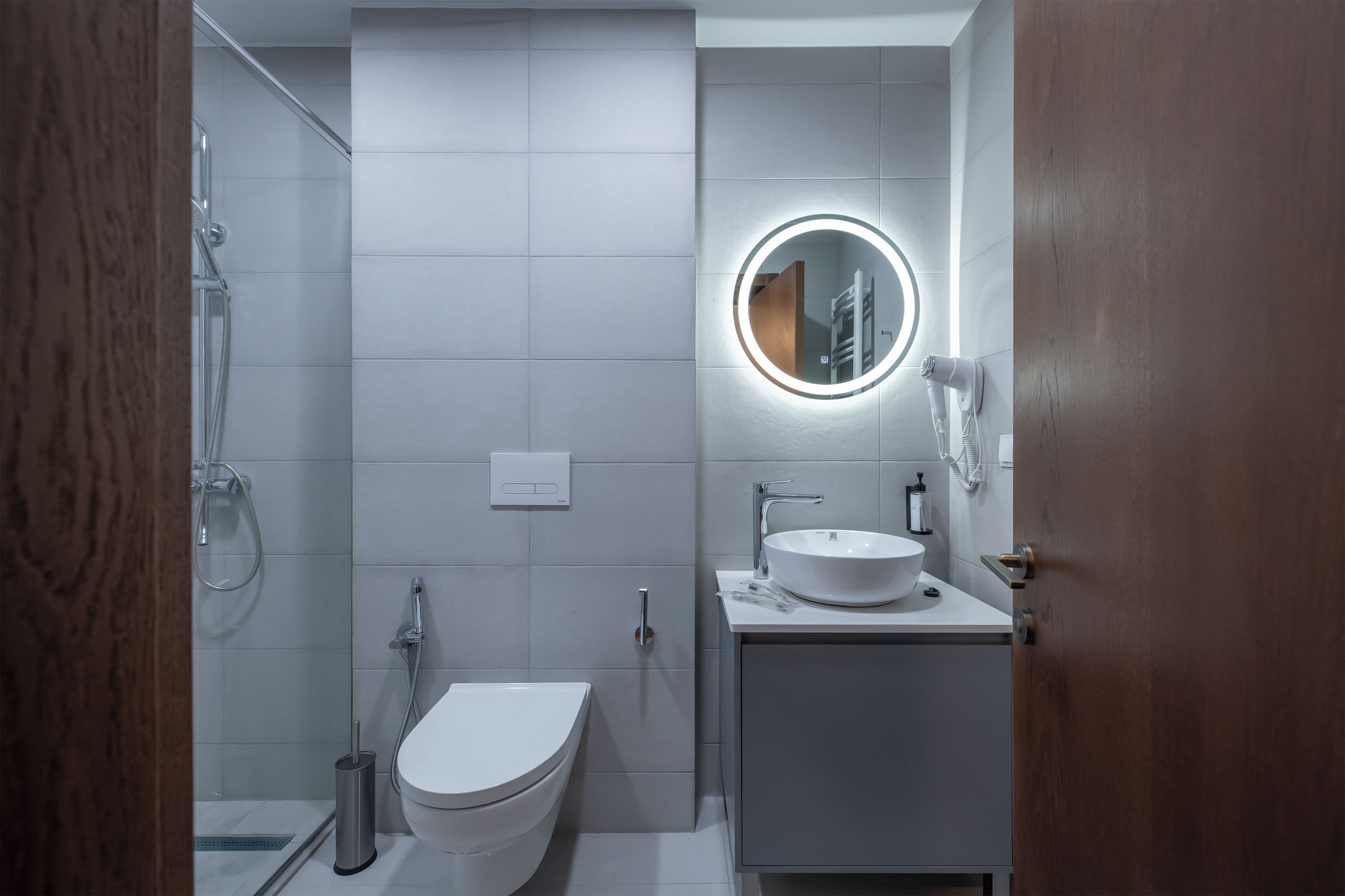 A modern bathroom with a toilet, sink, and shower.