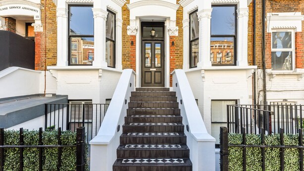 A multi-story building with a central entrance, a staircase, and a gated entrance. - Studio 9 @ OneStay Maida Vale (London)