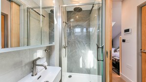 A modern bathroom with a glass-enclosed shower, a white sink, and a large mirror. - Studio 18 @ OneStay Maida Vale, Studio 18 at One Stay (London)