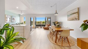 A spacious dining area with a long wooden table, chairs, and a view of the outdoors.