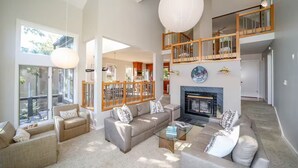 A spacious living room with a fireplace, a high ceiling, and a balcony. - Cliffs Edge-A Contemporary Mountain Home (Wintergreen Resort)