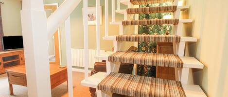 A staircase with a striped carpet and white railings.