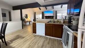 A modern kitchen with wooden flooring, built-in appliances, and a large island.