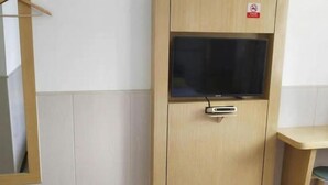 A wooden cabinet with a television and a digital screen, a wooden chair, and a small table. - Wen Feng Hotel (Shanghai)
