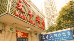 A hotel sign with the name "WenFeng Hotel" and a welcome sign below it. - Wen Feng Hotel (Shanghai)
