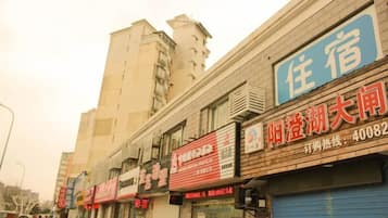 Uma fileira de edifícios comerciais com diferentes lojas, incluindo um hotel com placa azul.