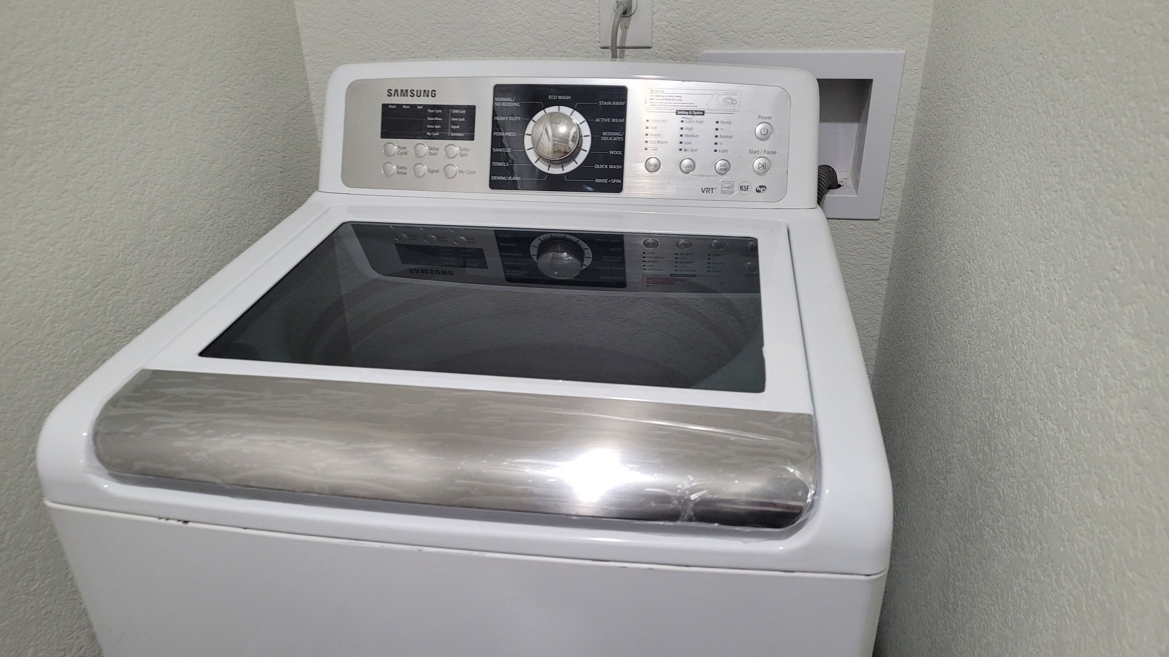 A Samsung front-loading washing machine with a control panel, a transparent door, and a white exterior.