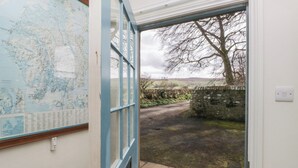 A door leading to a stone pathway with a map on the wall.
