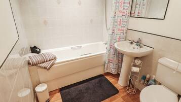 Un baño con bañera, lavamanos e inodoro.