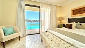 Ein Hotelzimmer mit Bett, Stuhl, Nachttisch und Blick auf einen Pool sowie Gebäude.
