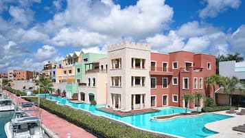 Un resort con piscina, edificios de colores y un muelle con barcos.